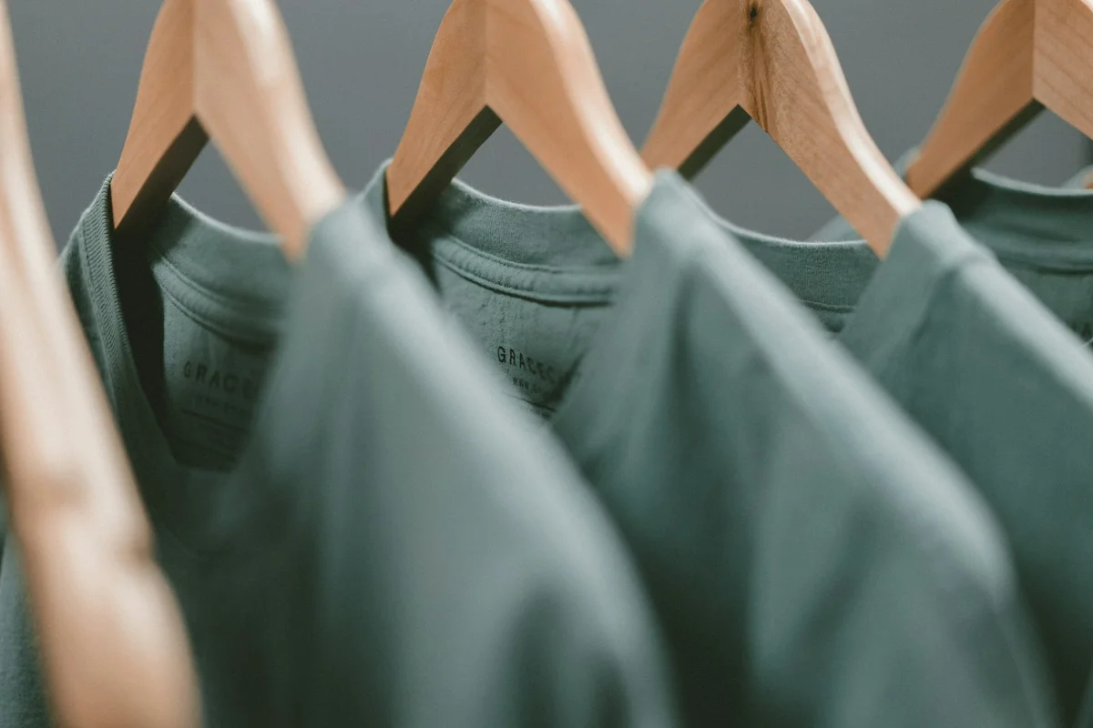 服装店内整齐陈列的服装货架，象征标准化连锁零售体系